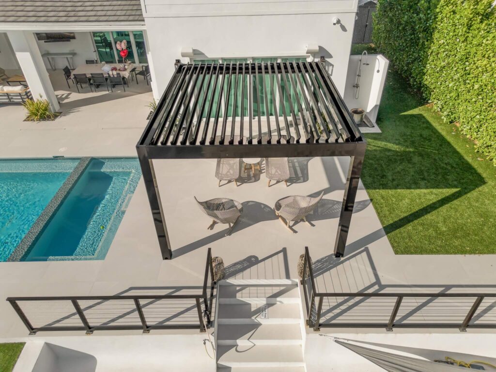 modern bioclimatic pergola installed beside a luxury florida swimming pool